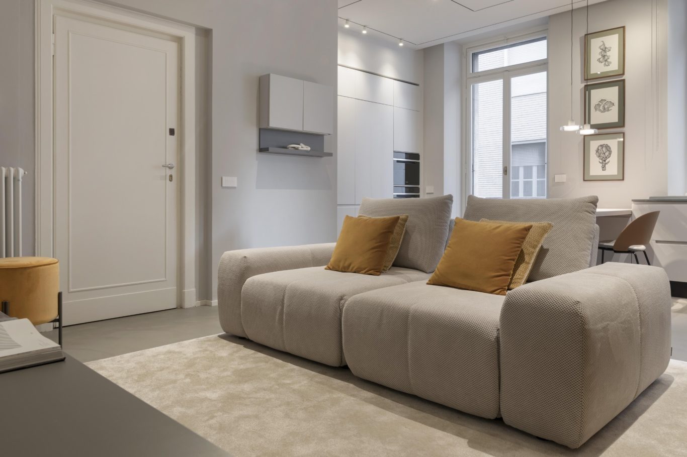 Séjour Salon moderne avec canapé gris, coussins orange et décor minimaliste.